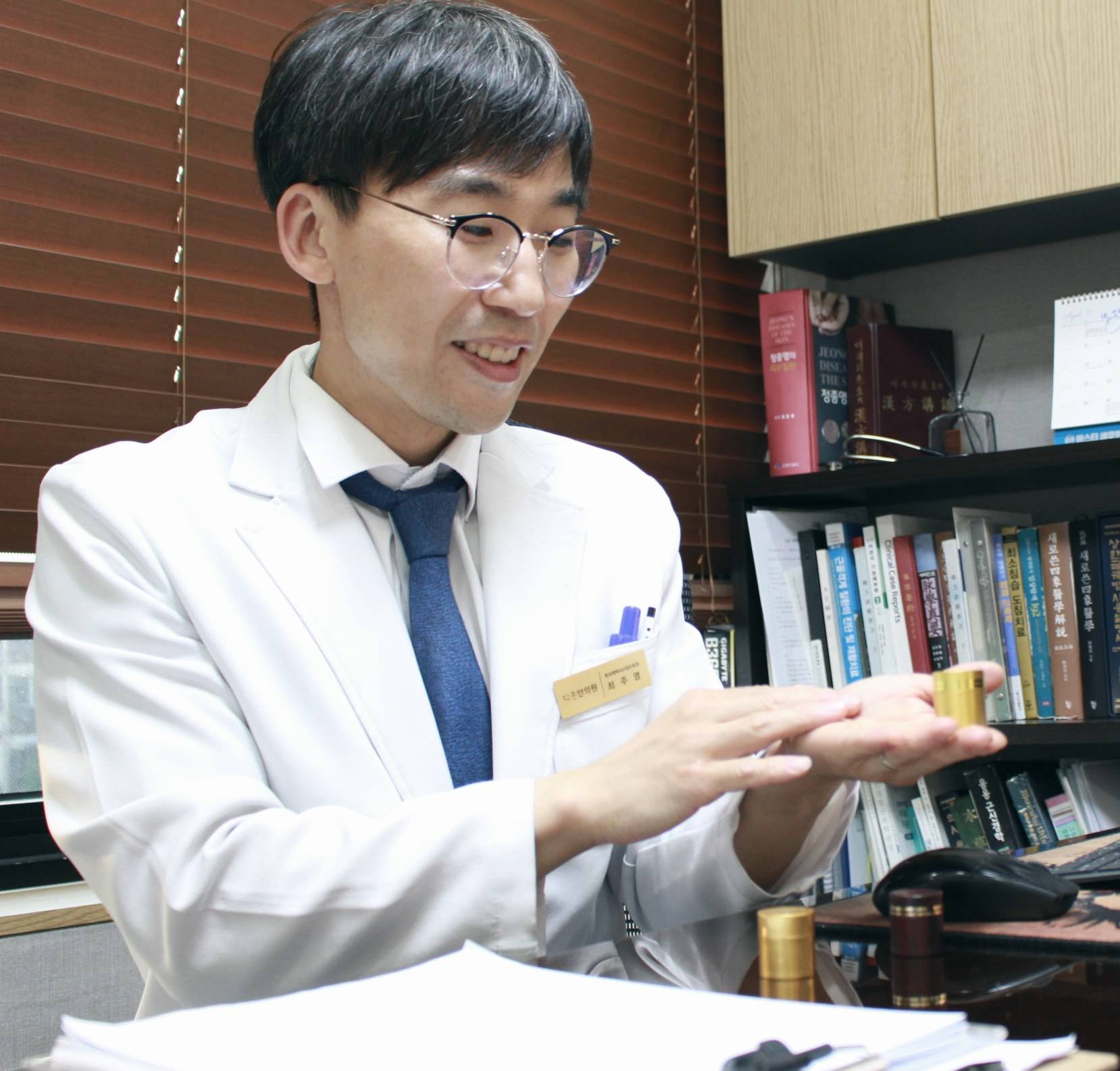 다온한의원 최주영 대표원장이 진료실에서 금색 케이스를 손에 들고 설명하는 모습